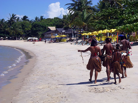 Niñas pataxós vendiendo collares en la playa